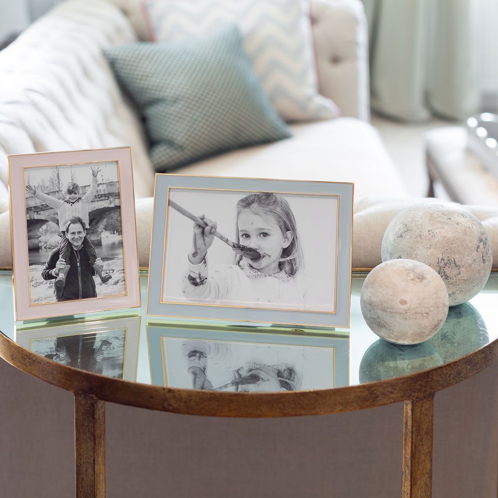 A pair of gold trim enamel photo frames